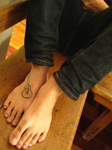Tatuaje en el pie,  simple contorno de guitarra pequeña