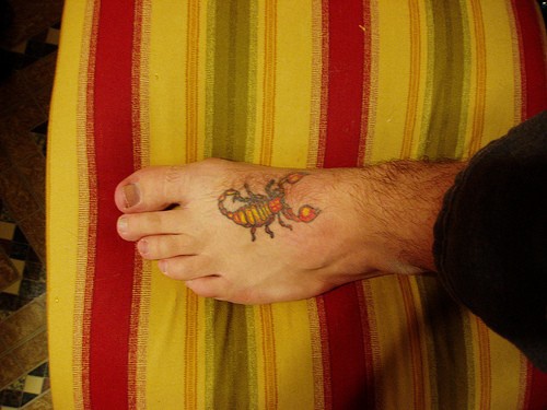 Colourful well-fed scorpion tattoo on foot