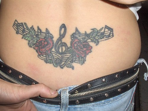 Tatuaggio colorato sulla lombo le rose e la chiave di violino