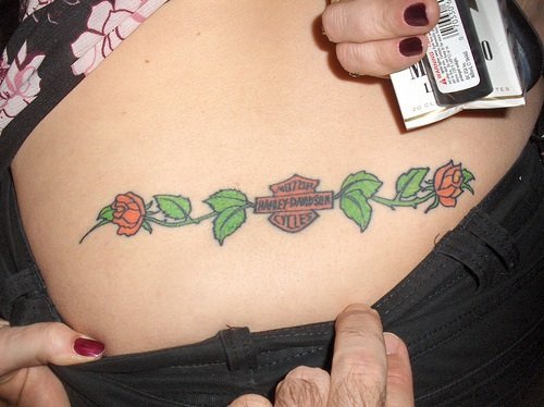 Tatuaggio colorato sulla lombo le rose & harley davidson