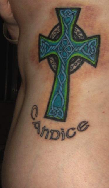 Tattoo on side of ribs, blue styled cross, candice