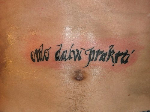 Tatuaje en vientre con una inscripción pequeña