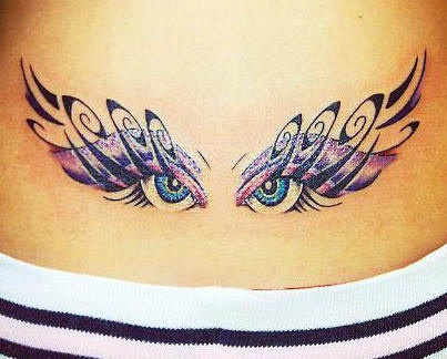 Tribal eyes lower back tattoo