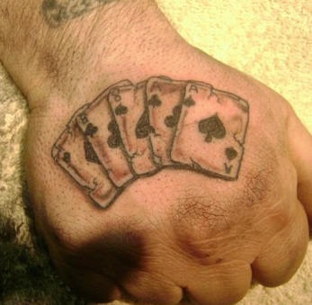 Cinque carte da gioco tatuate sulla mano
