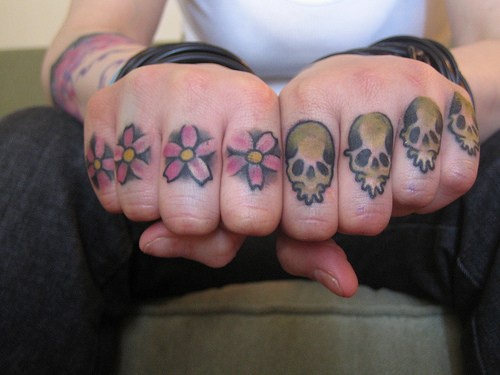 Tatuaje en los nudillos, flores, cráneos