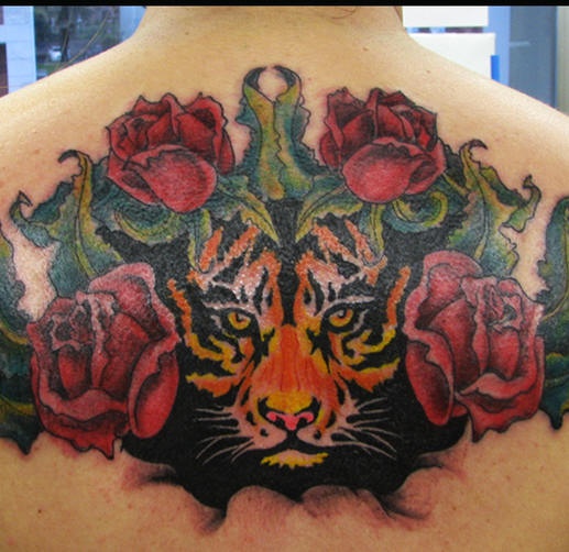 Hocico del tigre entre las rosas impresionante tatuaje en la espalda