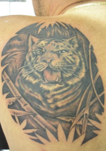 Tigre de nieve en el bosque tropical tatuaje en el hombro