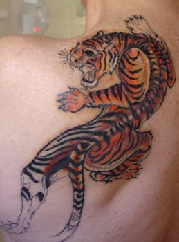 Colourful crawling tiger tattoo on upper back
