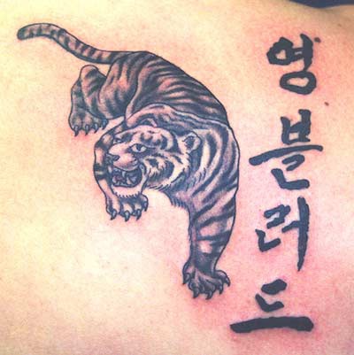 Tatuaje del tigre en tinta negra con jeroglíficos estilo asiático
