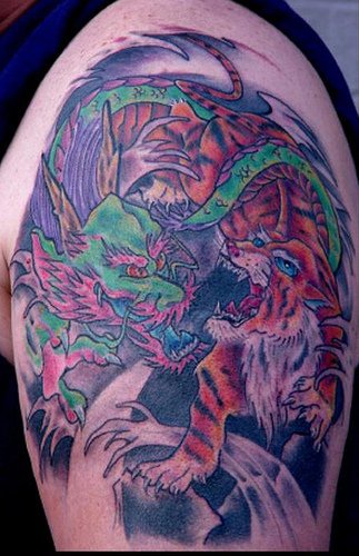 Batalla entre tigre y dragón verde tatuaje en el hombro