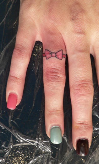 Tiny bow tattoo on finger