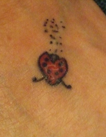 Tiny ladybug tattoo on foot