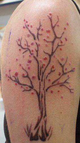 Art tree tattoo with red blossoms