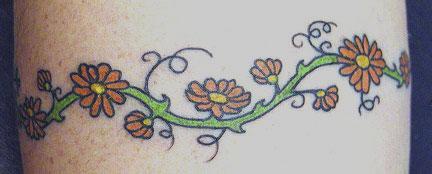 el tatuaje de la traceria florar en forma de brazalete hecho en color