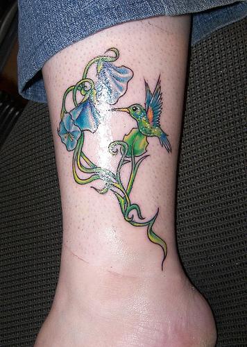 Baum Tattoo mit blauen Blumen und Kolibri