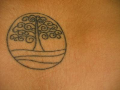 el tatuaje minimalista de una arbol lineado dentro de un circulo