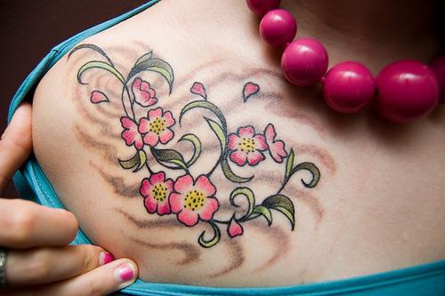 el tatuaje femenino con una traceria floral de color