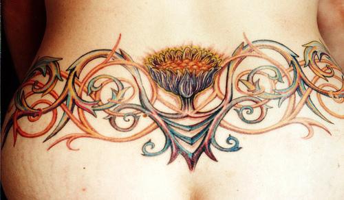 el tatuaje hermoso de una traceria con flores hecho en la espalda