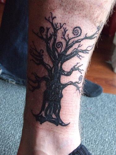 Dark black tree tattoo on leg