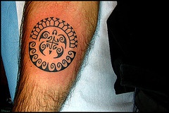 Tribal circle arm tattoo with turtle and small waves