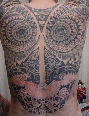 Tatuaje máscara estilo tribal en la espalda
