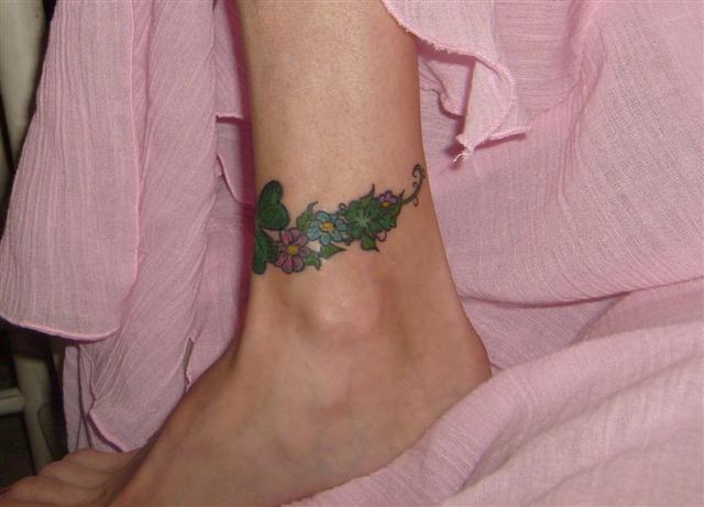 fiore qadrifoglio tatuaggio sulla gamba
