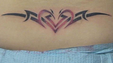 Le tatouage de bas du dos de cœur en style tribal
