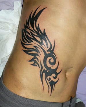 Winged tribal sign hip tattoo
