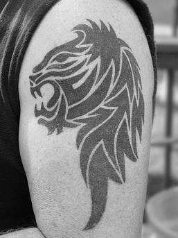Tribal blac ink lion head tattoo
