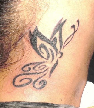 el tatuaje tribal con una mariposa hecho en tinta negra