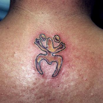 Kleines Tribal Symbol Tattoo am Nacken