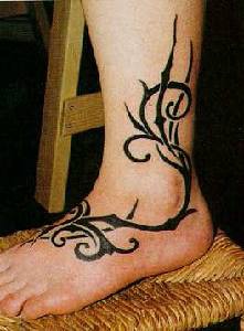 Vid estilo tribal en tinta negra tatuaje en la pierna