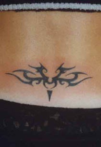 Small tribal sign tattoo on lower back