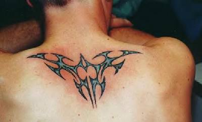 Tatuaje tribal en tinta azul parte superior de la espalda