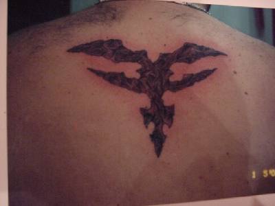 Tatuaje estilo tribal en tinta oscura en la espalda