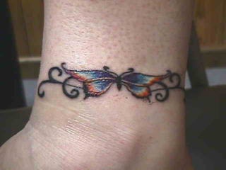 Tribal bracelet tattoo with butterfly and curls
