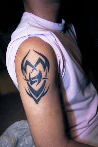 Tatuaje en el hombro el signo tribal en tinta negra