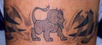 Tattoo with lion and two tribal signs
