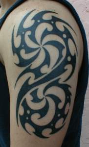 Shoulder tattoo with tribal black vortexes