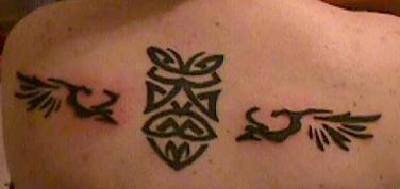 Tatuaje en tinta negra estilo tribal signo con las alas en  la parte superior de la espalda