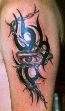 Tatuaje en tinta oscura el signo tribal con el ojo muy realístico