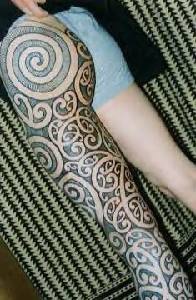 Tribal tattoo on whole leg in black color