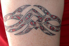Small tribal sign tattoo with red decoration