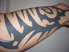 Black arm tattoo in tribal style