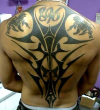 Black ink tribal back tattoo with inscription 8%
