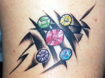 Pequeño tatuaje tribal con piedras preciosas en color