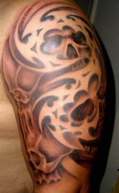 Tatuaje marrón dos calaveras en el hombro