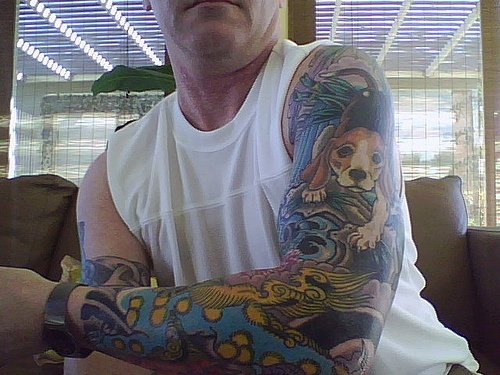 Colourful puppy themed sleeve tattoo