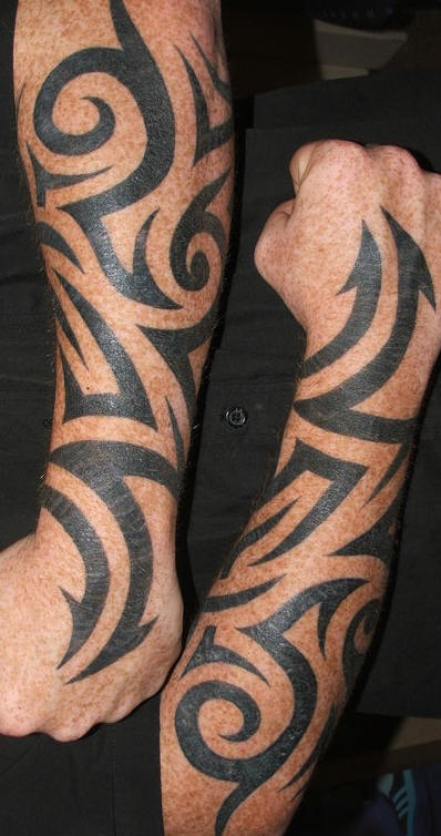 Tatuaje en tinta negra en las mangas estilo tribal
