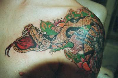 Super realistic snake tattoo on shoulder